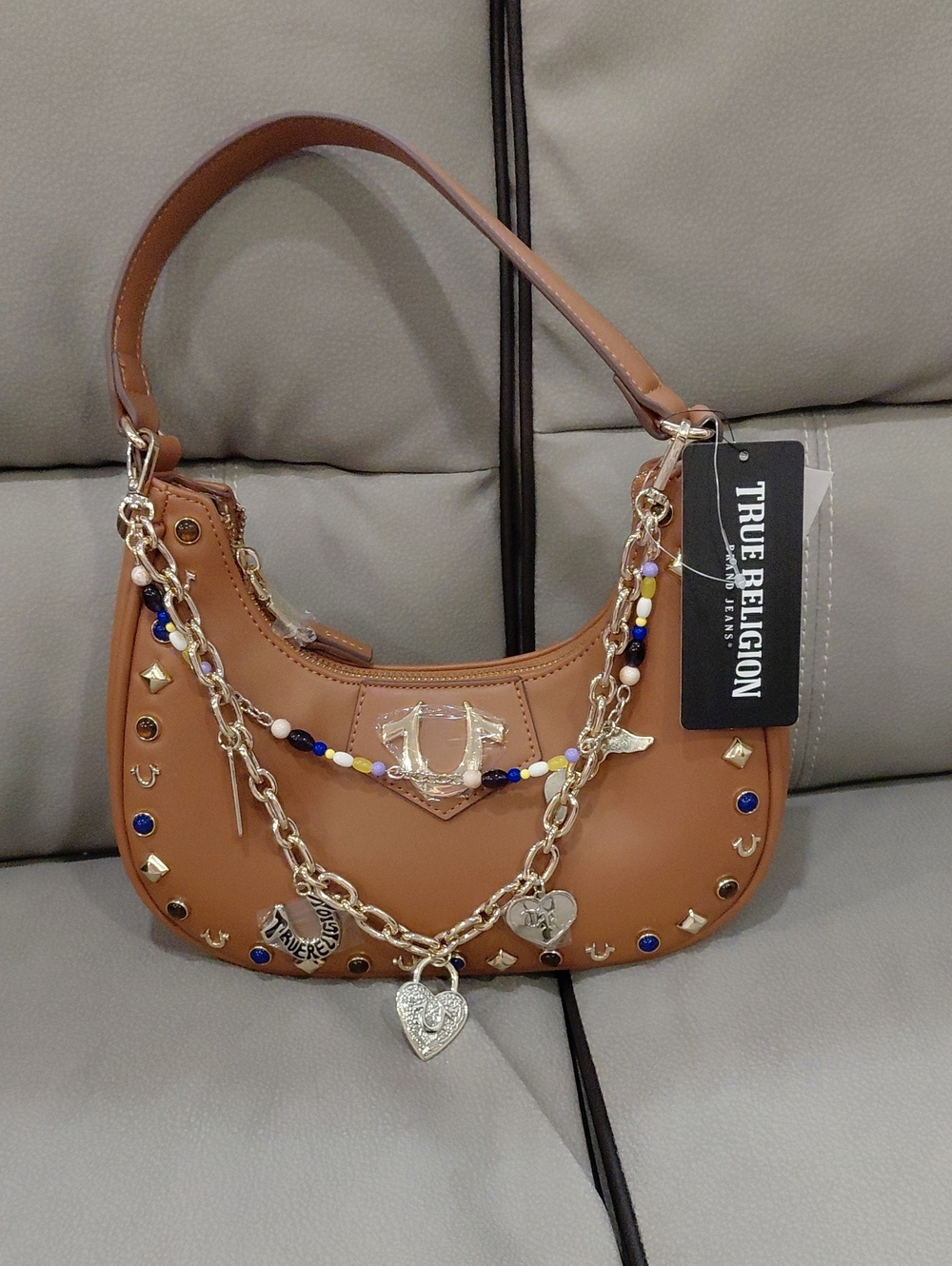 True Religion Tan Shoulder Bag with Gold Charm Chain and Blue Accents